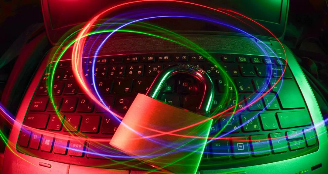 Här ser vi en laptop med ett hänglås ovanför tangentbordet. Vi runt allt detta ser vi virvlar i blått, rött och grönt. Bilden ska symbolisera säkerhet på internet.