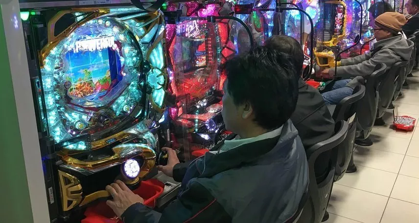 Japaner sitter på rad och spelar japanskt spel.
